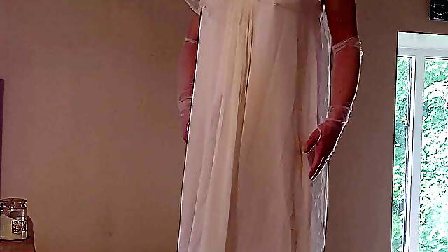 Sissy wearing a wedding dress caged and plugged